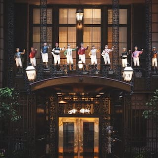 A row of brightly coloured jockey figurines above a restaurant entrance