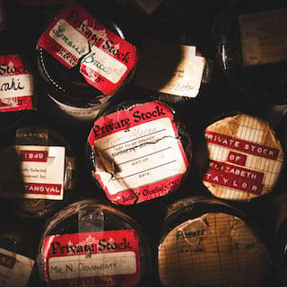 Vintage wine bottles stacked upon each other with old labels